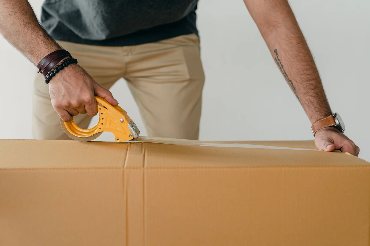 Hands sealing a customer parcel with packing tape