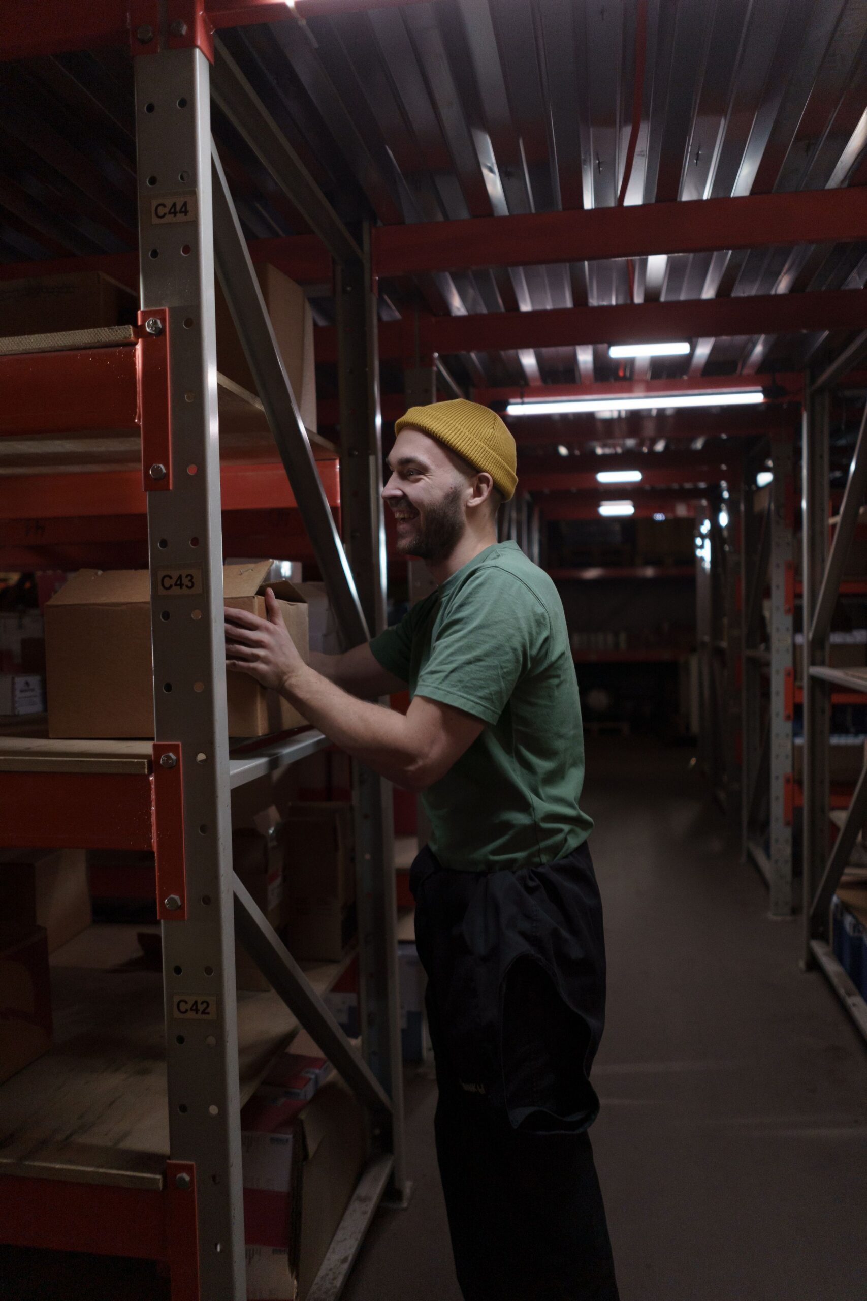 Worker picking a carton from warehouse shelving