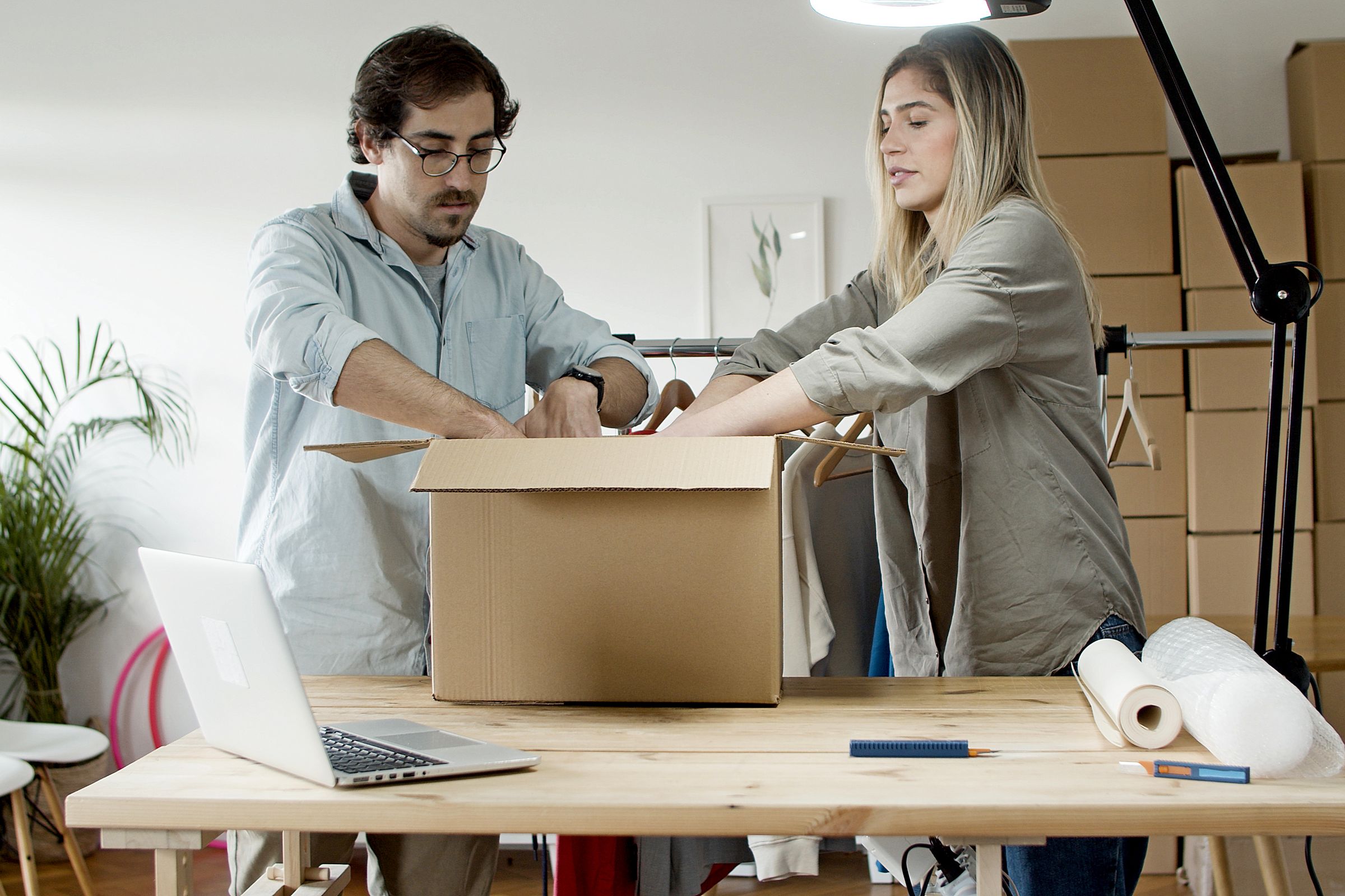 Two people packing ecommerce products into a carton