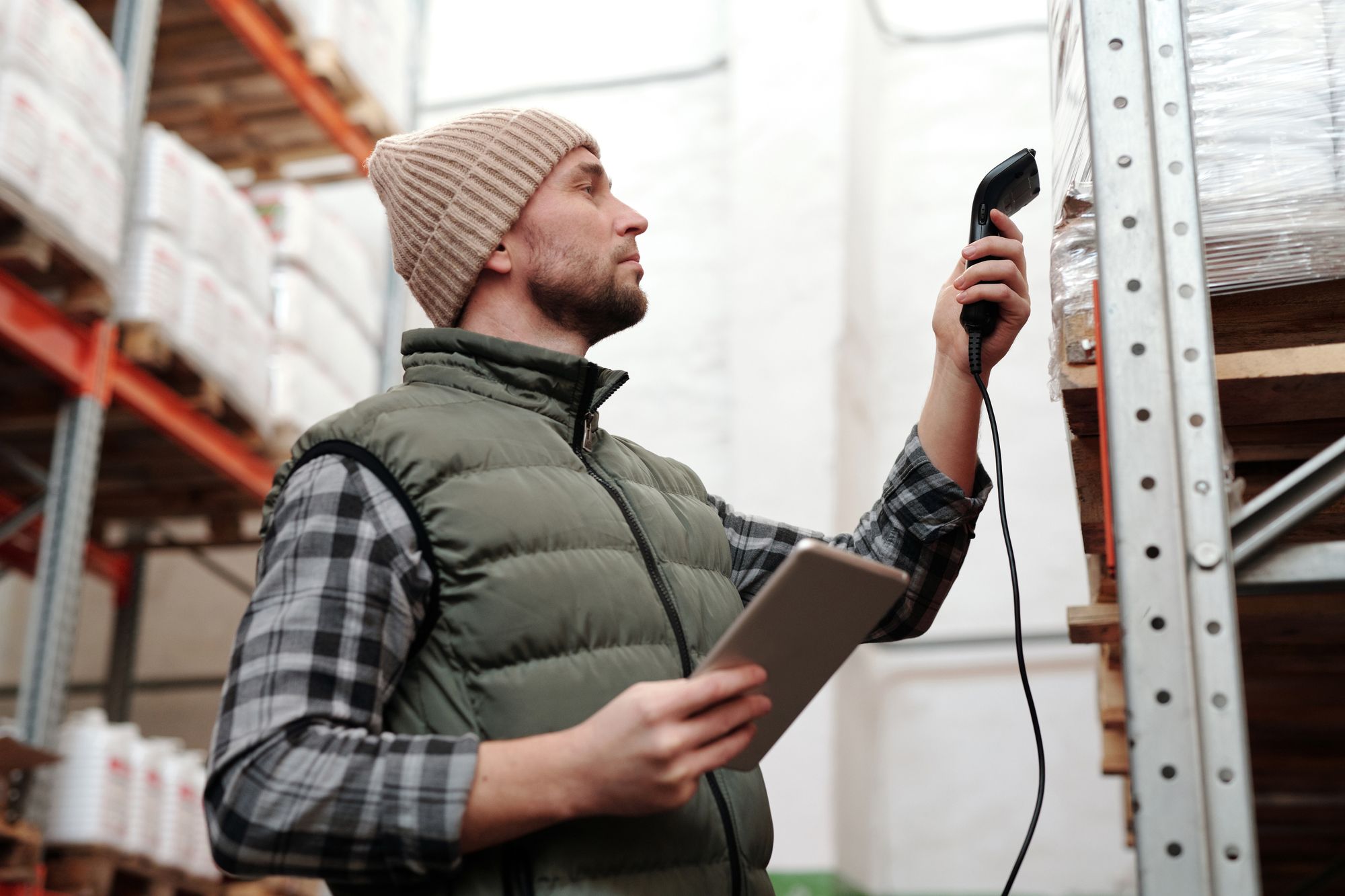 Warehouse worker using a handheld barcode reader to check stock