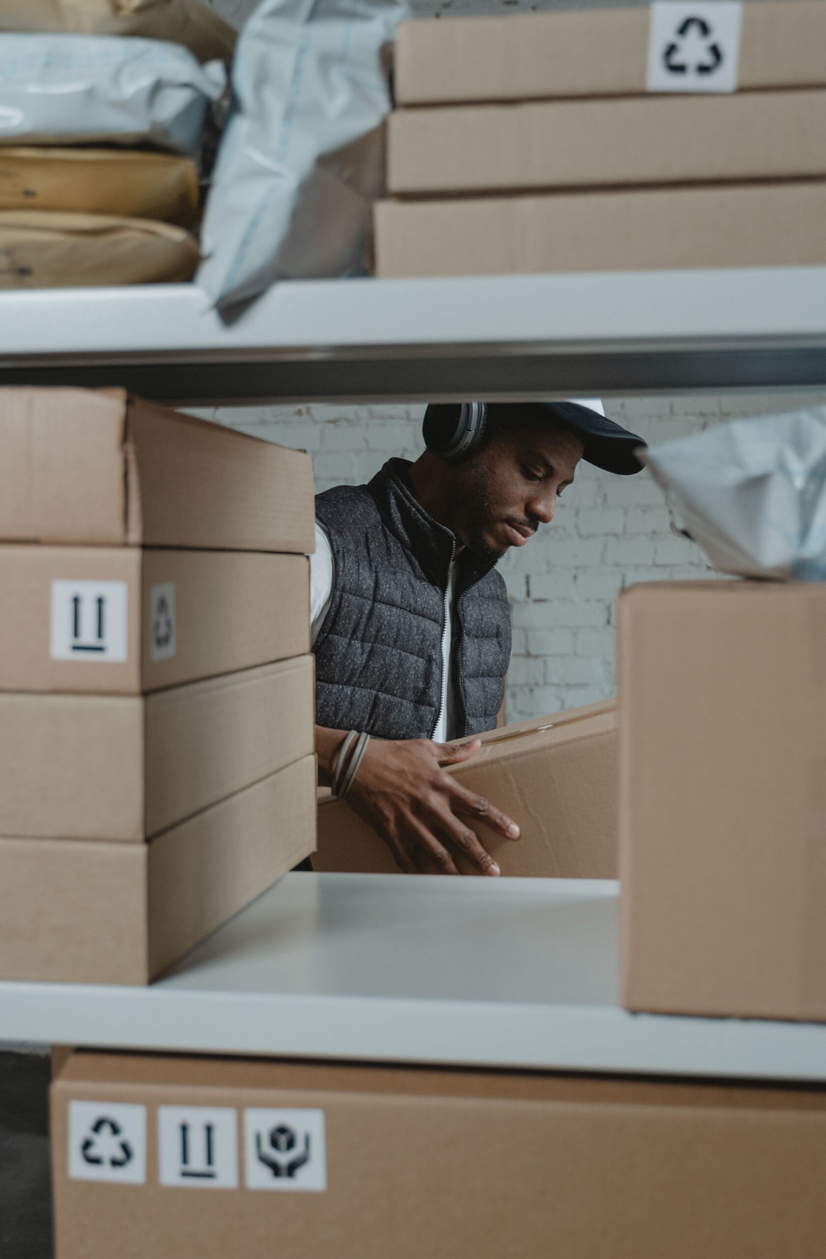 Warehouse staff sorting supplier cartons on shelving